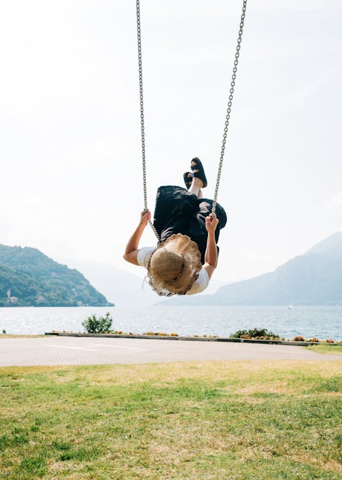 ragazza che gioca con altalena in riva sul lago di como