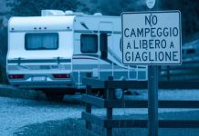 Campeggio a Giaglione: il sindaco dichiara guerra a camper, roulotte e tende per il 2025 una roulotte in un parcheggio a Valsusa, con un cartello che indica no campeggio a giaglione