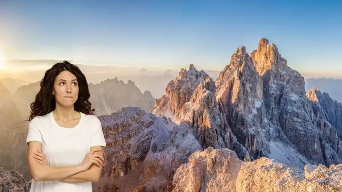 ragazza dubbiosa tra le dolomiti che pensa ai peggiori rifugi di montagna in italia