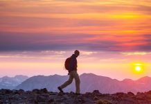 Recensione Rifugio Pedrotti: Un’Oasi Alpina nel Cuore delle Dolomiti, Guida Essenziale per il 2025 ragazzo che fa trekking al tramonto analizzando la recensione rifugio pedrotti