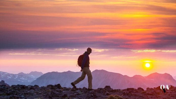 ragazzo che fa trekking al tramonto analizzando la recensione rifugio pedrotti